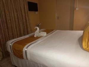 uma grande cama branca com uma decoração de cisne em Rest Shade Bed and Breakfast em Palapye