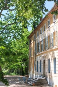 an old building with blue benches in front of it at Chateau de Saint Martin in Taradeau