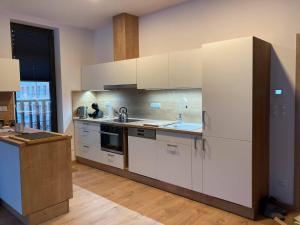 a kitchen with white cabinets and a sink at Apartmán T5 Herlíkovice in Vrchlabí