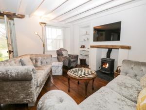 a living room with couches and a fire place at Bridge End Cottage in Ulverston
