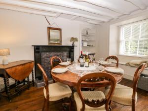 a dining room with a table and chairs and a fireplace at Bridge End Cottage in Ulverston