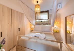a bedroom with a bed with a chandelier at En Lefko Boutique Apartments in Nikiana +19 photos