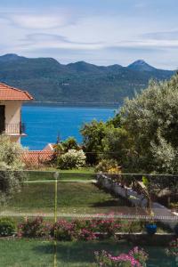 a view of a lake from a house with flowers at En Lefko Boutique Apartments in Nikiana