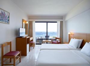 a hotel room with two beds and a view of the ocean at Cactus Hotel in Rhodes Town