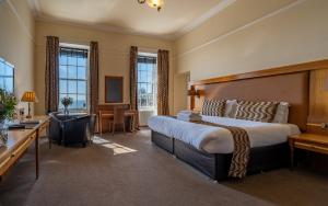 a hotel room with a large bed and a television at The Bank in Anstruther