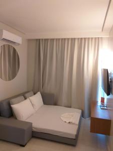 uma cama num quarto com um sofá e uma televisão em Salinas Exclusive resort em Salinópolis