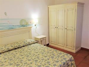 a bedroom with a bed and a cabinet in it at White Sand Residence in Murta Maria