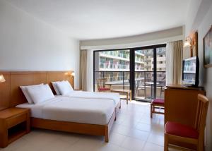 a hotel room with a bed and a balcony at Cactus Hotel in Rhodes Town