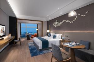 une chambre d'hôtel avec un lit et une salle à manger dans l'établissement Ascott Xiangjiang FFC Changsha, à Changsha