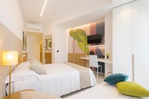 um quarto com uma cama branca e uma secretária em Hotel Bellavista - Boutique Hotel em Otranto