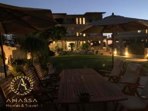 a patio with a table and chairs and an umbrella at Swash & Ripple Studio by the sea in Mytikas