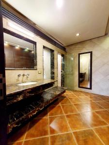 a bathroom with a sink and a mirror at Luxurious Boutique One Bed Apartment In Bahria Town in Rawalpindi
