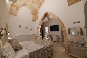 una camera con letto e soffitto a volta di PLAZACARRISI HOTEL & SPA a Cellino San Marco