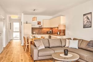 ein Wohnzimmer und eine Küche mit einem Sofa und einem Tisch in der Unterkunft Adler Lodge D2 by AA Holiday Homes in Tauplitz