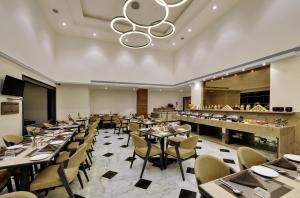 a restaurant with tables and chairs and a bar at Comfort Inn Sunset in Ahmedabad