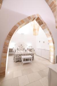 an archway in a white room with a bed at PLAZACARRISI HOTEL & SPA in Cellino San Marco