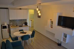 a kitchen and a living room with a table and chairs at Fancy Beach Apartment in Mamaia