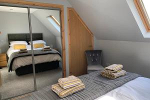 a attic bedroom with a bed and a mirror at The Nest - Near Inverness & Loch Ness in Inverness