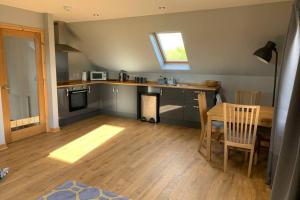 a kitchen with a table and a dining room at The Nest - Near Inverness & Loch Ness in Inverness