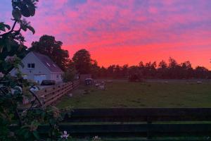a barn in a field with a red sky at The Nest - Near Inverness & Loch Ness in Inverness