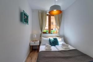 a small bedroom with a bed and a window at Apartamenty Sun Seasons 24 - Leśny Dom in Karpacz