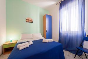 トリカーゼにあるB&B A Casa di Daniloのベッドルーム1室(ブルーベッド1台、タオル2枚付)