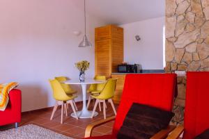 cocina con mesa y sillas amarillas y rojas en Quinta da Aurora, en Évora 25 fotos más