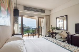 a hotel room with a bed and a balcony at Howard Johnson Resort Sanya Bay in Sanya