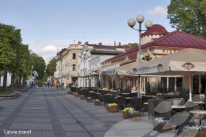 a city street with tables and chairs and buildings at Skolas street seaside space! in Jūrmala