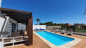 a swimming pool on the roof of a house at Villa BELLA on Golf in La Estancia, Caleta Fuste-Fuerteventura in Caleta De Fuste