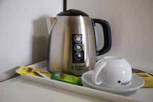 eine Kaffeekanne und eine Tasse auf einem Tablett in der Unterkunft HOTEL LIDIA in Mergo