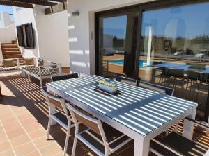 a blue table and chairs on a patio at Villa BELLA on Golf in La Estancia, Caleta Fuste-Fuerteventura in Caleta De Fuste