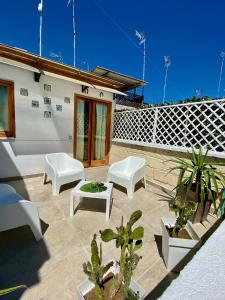 a patio with white furniture and plants on a building at B&B Le Statuine in Barletta