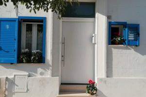 een wit huis met blauwe ramen en een deur bij Blue Sail Apartment in Termoli
