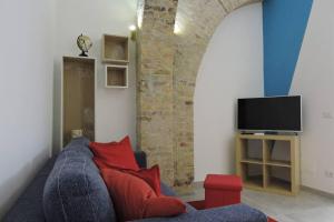 uma sala de estar com um sofá azul e uma televisão em Blue Sail Apartment em Termoli