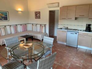 a kitchen with a table and chairs in a room at Les Villas de Lava in Appietto