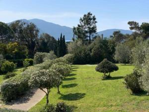 un jardin avec des arbres et des buissons dans un champ dans l'établissement Les Villas de Lava, à Appietto