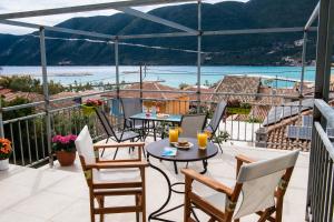 a balcony with tables and chairs and a view of the water at Mediterraneo studios in Vasiliki
