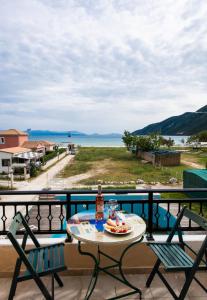 a table and chairs on a balcony with a view of the ocean at Calypso Luxury Studios in Vasiliki