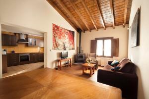 a living room with a couch and a kitchen at Apartamentos La Calvera in Parres de Llanes