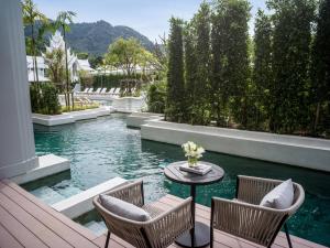 a patio with chairs and a table in the water at InterContinental Phuket Resort by IHG in Kamala Beach +37 photos