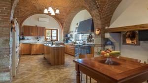 a kitchen with a table with a bowl of fruit on it at Villa Siena 10, Emma Villas in Castelnuovo Berardenga