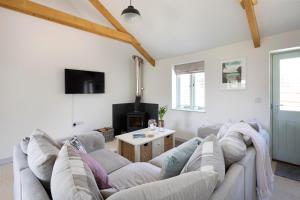 a living room with a couch and a table at Cart Shed Cottage in Truro