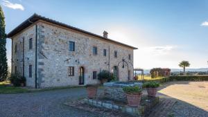 an old stone building with potted plants in front of it at Villa Siena 10, Emma Villas in Castelnuovo Berardenga