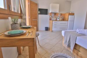 a room with a table and a bed and a kitchen at The Wave House in Mochlos
