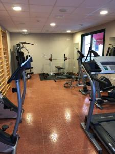 a gym with several tread machines in a room at Hotel Balneario de La Virgen in Jaraba