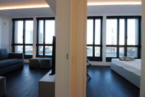 a living room with a bed and a couch and windows at Number House - Number 11 in Milan