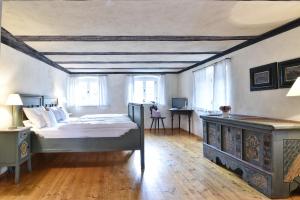 a bedroom with a bed and a table and windows at Gentner - Hotel garni in Gnotzheim