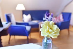 eine Vase mit Blumen auf einem Tisch im Wohnzimmer in der Unterkunft Gentner - Hotel garni in Gnotzheim