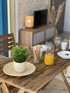 a wooden table with a plate of food and orange juice at En Lefko Boutique Apartments in Nikiana